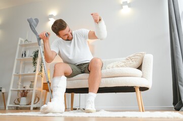Happy man recovery from accident fracture broken bone injury with leg and arm. Social security and...