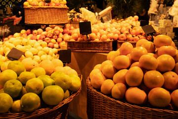 Tangerines, apples and limes in wicker baskets in supermarket
