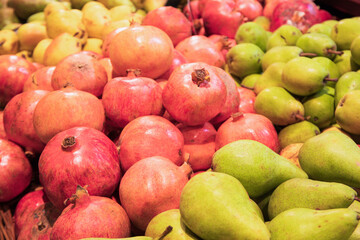 Pears and pomegranates in supermarket, close up
