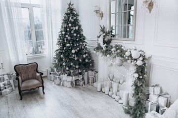 Cozy flat apartment photo studio room green Christmas Tree gifts presents garlands, candles white decorated toys balls interior New Year lights glowing bokeh
