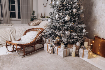 Cozy flat apartment photo studio room sled sleigh green Christmas Tree gifts presents garlands, candles decorated toys balls interior New Year lights glowing bokeh 
