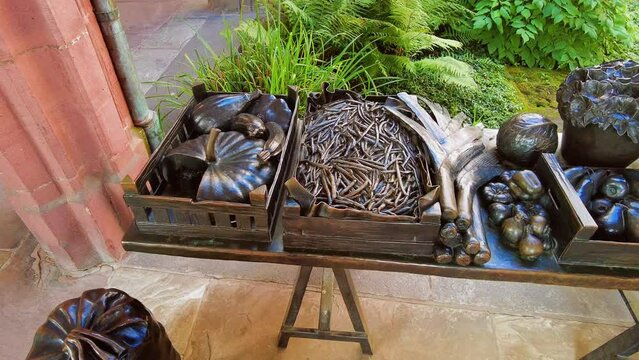 Panning over metal sculpture depicting different types of food at Basel Minster, Switzerland.
