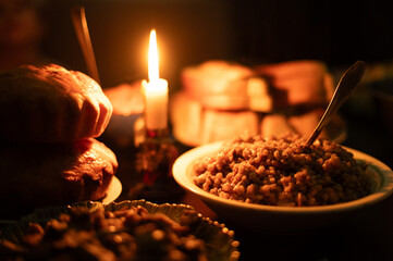 Christmas Eve in a Ukrainian family. Kutya on the table and a lighted candle.