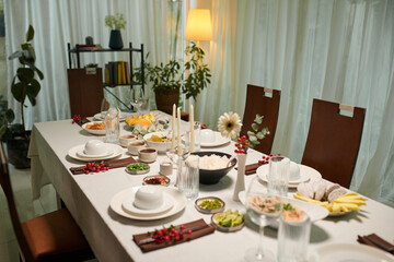 Dinner table with various dishes decorated with flowers and candles