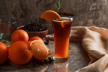Iced Americano black coffee with lower layer orange juice in the glass. Rosemary with cinnamon on...