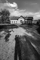 Cornet train station looking like old house, Romania, black and white travel photograph with male...