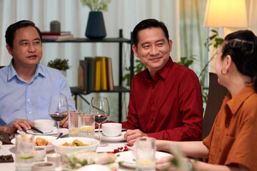 Family members discussing news at dinner party at home