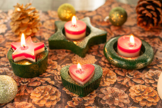 Teelichthalter mit brennenden Kerzen für Weihnachten in Grün mit Glitzerstaub