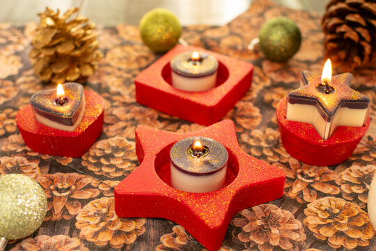 Teelichthalter mit brennenden Kerzen für Weihnachten in rot mit Glitzerstaub.