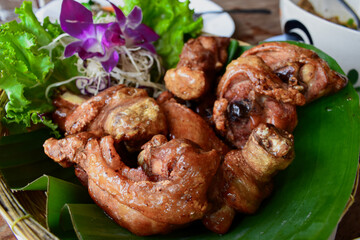 The crispy fried chicken, seasoned with salt, was presented on fresh green banana leaves.