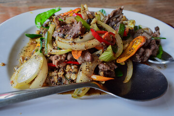 The delicious stir-fry included meat, bell pepper, and onion as its primary components, all seasoned with black pepper. 