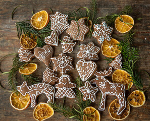 Ręcznie dekorowane ciastka z kolorowym lukrem ułożone na drewnianej desce w świątecznej aranżacji.