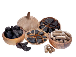 one whole and one cut across black fermented garlic bulb