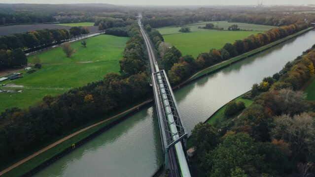 Regional train crossing a river bridge , agricultural fields in Europe Germany, aerial footage	