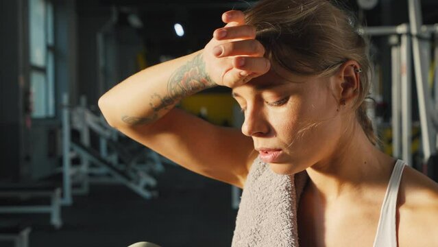 Exhausted woman takes break to return energy after workout