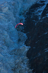 paraglider in front of the ice of Glacier des Bossons in Chamonix