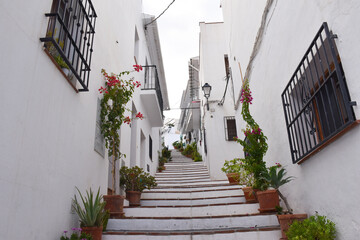 Fototapeta na wymiar Frigiliana, el municipio con paredes de casas y escalera blancas 