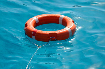 Lifebuoy on the waves. Bright blue sea. Place for text. Concept: yachting, sailing yachts, seaside holidays