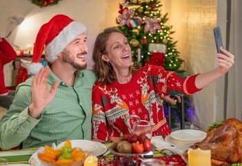 Family looking at camera selfie photo by smartphone in celebration party enjoy happy at dinner together with full food of turkey celebrate merry xmas in Christmas thanksgiving and New Year festive.