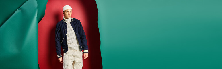 banner of handsome man in beanie, sweater and bomber jacket on ripped red with turquoise backdrop