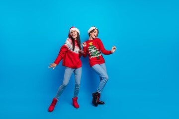 Full length photo of adorable sweet women santa elves wear ornament pullovers enjoying x-mas disco isolated blue color background