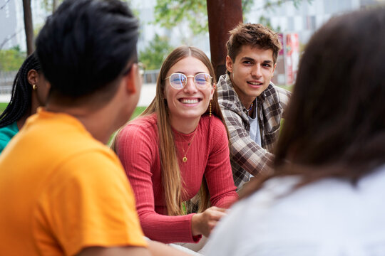Close up of a group of university students gathering outside campus, reunited to study together.