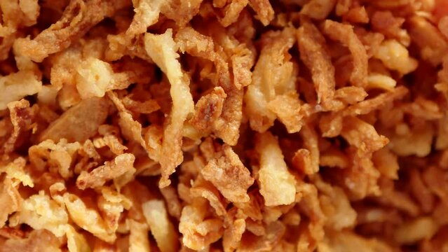 Crispy onions texture. Fast food dried topping. Fried flakes. Rotating video