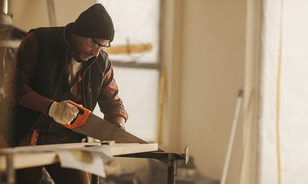 Skilled contractor cutting wood and carrying out kitchen renovation with precision