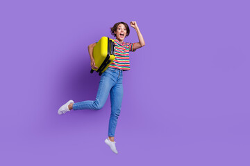 Full length photo of optimistic girl in trendy clothes hold suitbag rejoice resort abroad empty space isolated on violet color background