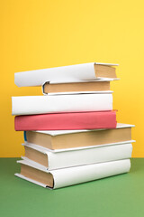 Books stacking. Open hardback books on wooden table and green background. Back to school. Copy space for ad text.