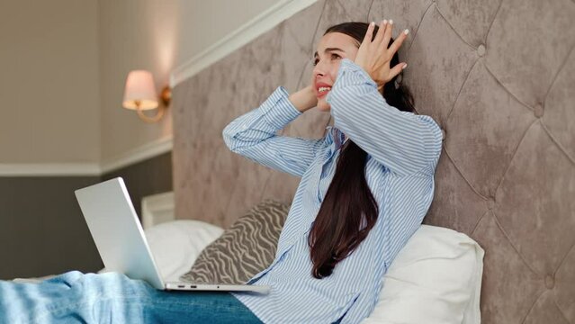 Young irritated woman trying to work annoyed by bad noisy room neighbors covering ears with hands, angry girl manager disturbed with loud noise problem wake up lying in bed suffer from soundproofing.