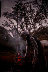 Fototapeta premium Frau am Lagerfeuer im Wald