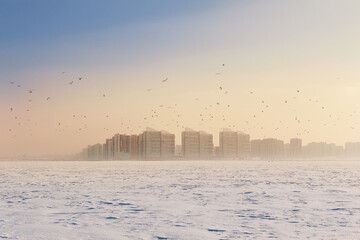 Fototapeta premium Winter landscape with snow covered frozen ice and city
