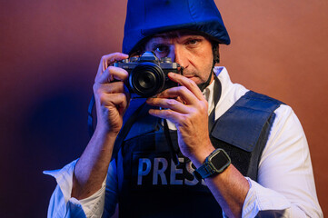 Obraz premium Reporter in bulletproof vest with a camera.