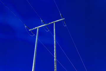 blue night sky with power lines on old wooden poles