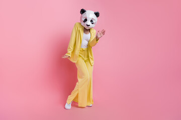 Full body portrait of crazy strange 3d panda mask lady dancing empty space isolated on pink color...