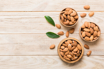 Fresh healthy Almond in bowl on colored table background. Top view