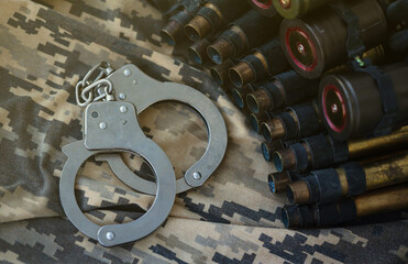 Ukrainian army machine gun belt shells and handcuffs on military uniform. Concept of bribery and...