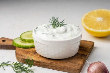 Obraz na płótnie Canvas Greek yogurt-based tzatziki sauce in a white bowl.