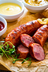 Fried sausages, onion and bread on wooden table
