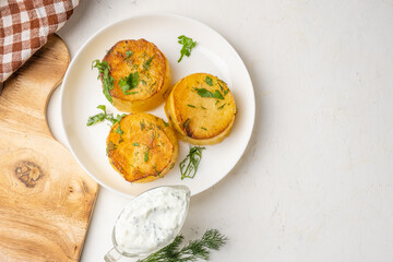 Melting potato fondant, potatoes in a white plate on a wooden board, top view, free space.