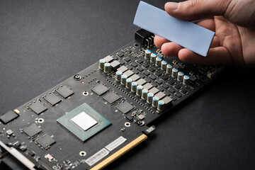 A computer technician repairs a computer. Cleaning the video card. Replacing thermal paste and...
