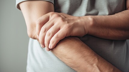 a man support his hand and arm that having symptoms of pain,numbness,weakness,paralysis,muscle disorder, concept of Guillain barre syndrome caused by autoimmune disorder 