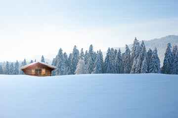 Holzhütte in einer verschneiten Winterlandschaft