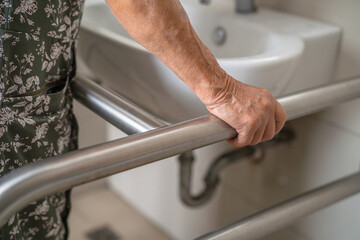 Asian elderly woman patient use toilet bathroom handle security in nursing hospital, healthy strong medical. - obrazy, fototapety, plakaty