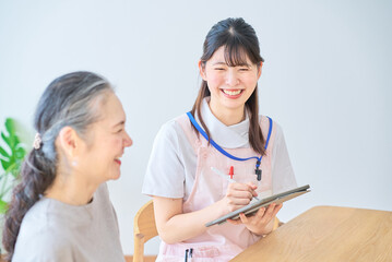 会話するシニア女性とエプロン姿の若い女性