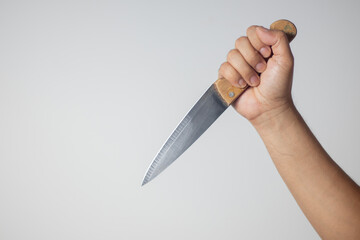 Male hand holding a knife on white background