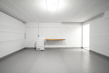 Apartment building common use empty laundry room. Empty wooden table top, dryer and hanging wires on the wall. Wide-angle view, no people