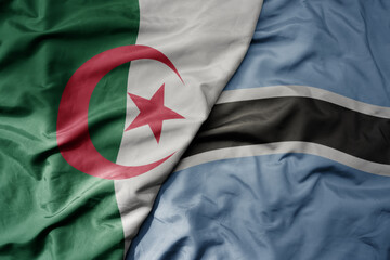 big waving national colorful flag of algeria and national flag of botswana .