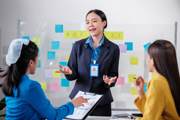 Business, board and Asian woman with presentation, planning and explain process at a workshop. Female person, presenter and speaker writing, brainstorming and motivation with profit growth and mentor
